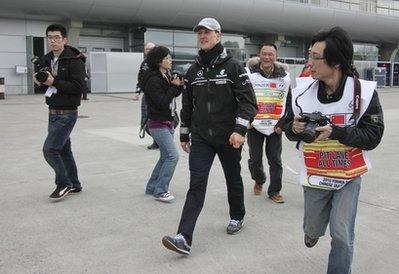 Mercedes&nbsp;Formula&nbsp;One&nbsp;driver&nbsp;Michael&nbsp;Schumacher,&nbsp;center,&nbsp;of&nbsp;Germany&nbsp;walks&nbsp;through&nbsp;the&nbsp;F1&nbsp;Paddock&nbsp;at&nbsp;the&nbsp;Shanghai&nbsp;International&nbsp;Circuit&nbsp;on&nbsp;his&nbsp;arrival&nbsp;at&nbsp;the&nbsp;Chinese&nbsp;Formula&nbsp;One&nbsp;Grand&nbsp;Prix&nbsp;in&nbsp;Shanghai,&nbsp;China,&nbsp;Thursday,&nbsp;April&nbsp;15,&nbsp;2010.(AP&nbsp;Photo/Eugene&nbsp;Hoshiko)