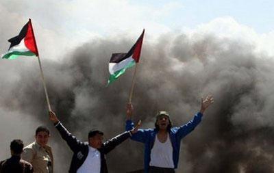 Palestinian&nbsp;youths&nbsp;wave&nbsp;their&nbsp;national&nbsp;flag&nbsp;and&nbsp;set&nbsp;tyres&nbsp;on&nbsp;fire&nbsp;as&nbsp;they&nbsp;clash&nbsp;with&nbsp;Israeli&nbsp;soldiers&nbsp;near&nbsp;the&nbsp;Gaza&nbsp;border.&nbsp;(AFP/Mahmud&nbsp;Hams)