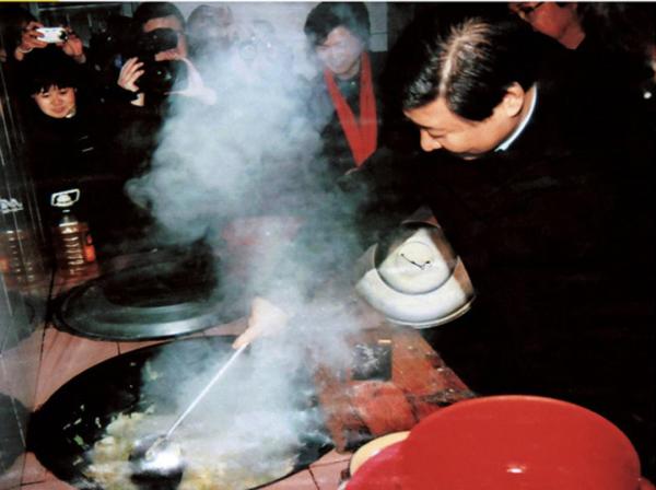 2007年1月，时任浙江省委书记习近平（右一）在浙江省庆元县屏都镇敬老院为老人们炒菜。