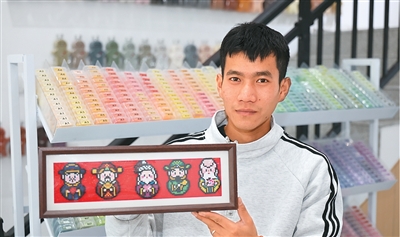 江苏省淮安市一家手工创意工坊内，消费者正在展示拼豆作品。殷 潮摄（人民图片）
